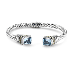 Our Sterling Silver 18k solid Gold twisted emerald cut blue topaz hinged bangle, handcrafted in Bali by our skilled artisans. From our signature collection, Royal Bali™ featuring designs handcrafted using sterling silver, solid 18k gold accents and genuine gemstones. The November birthstone, Topaz, symbolizes love and affection. It is believed to give the wearer increased strength and intellect.