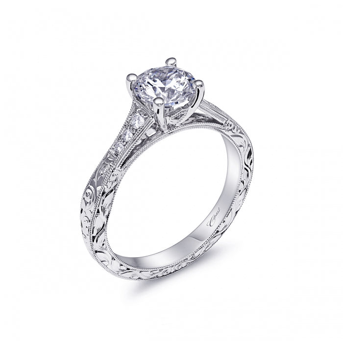 14K White Gold .08ctw Diamond Engagement Semi-Mount by Coast Diamonds.  This sophisticated engagement ring features an elegantly designed shank which tapers out towards the sides of the ring. The shank is adorned with exquisite hand engraving and set with fine pave diamonds at the top. Holds a 1 ct center stone.