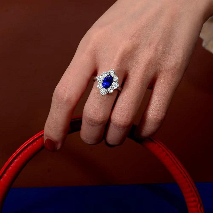 From the Victoria Collection by Anna Zuckerman, Elegant 1.5 carat sapphire blue crystalline oval in a halo of round diamond white round crystalline 5 tcw set in platinum plated sterling silver 925