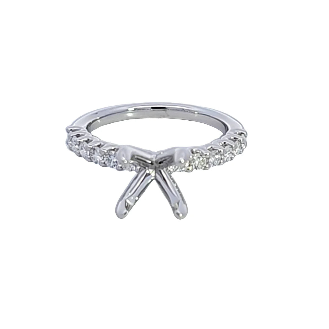 A silver-toned diamond engagement ring with a bow-shaped center and a pavé band, shown on a plain white background.