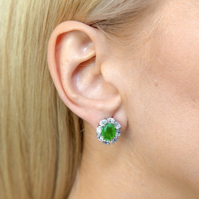 From the Victoria Collection by Anna Zuckerman Luxury, Sterling Silver Oval Emerald Green CZ Halo Stud Earrings.  Classic 2 carat oval emerald green or sapphire blue crystalline stud with diamond white crystalline halo 8 tcw set in platinum plated sterling silver 925.