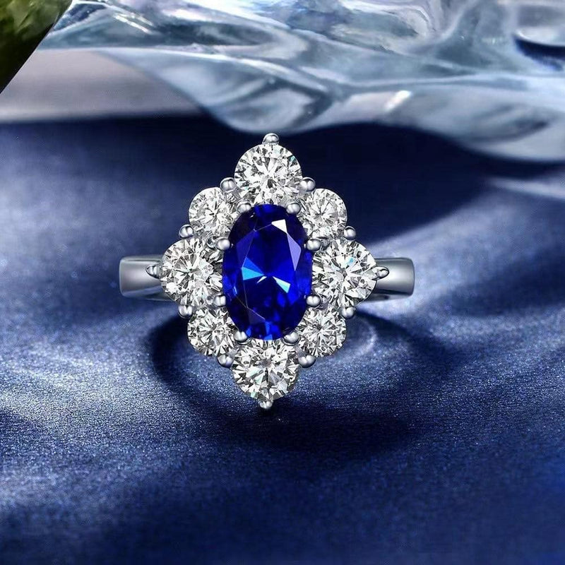 From the Victoria Collection by Anna Zuckerman, Elegant 1.5 carat sapphire blue crystalline oval in a halo of round diamond white round crystalline 5 tcw set in platinum plated sterling silver 925